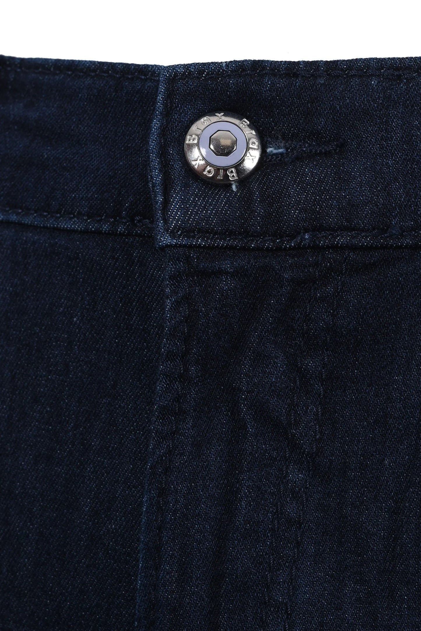Close up of the button and zip fly closure on a pair of Brax Chuck jeans in a dark denim colour, it has a branded Brax button in the colour blue.