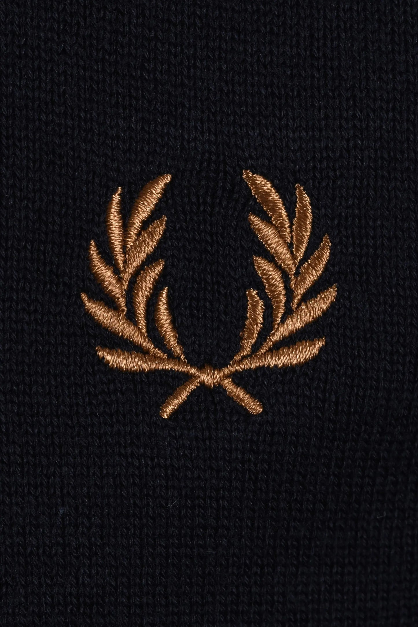 Embroidered gold fred perry logo on a navy polo