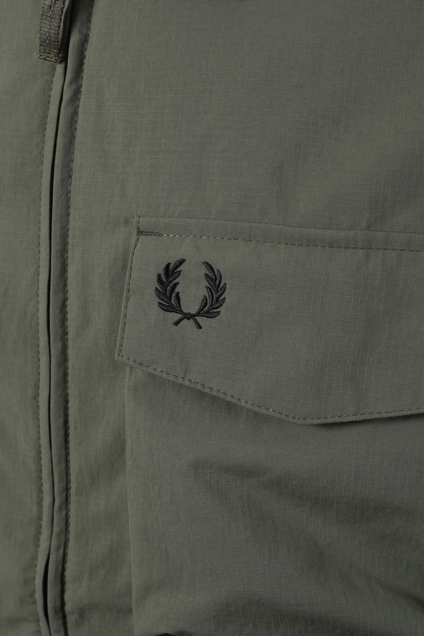 Close-up of a pocket on a jacket with a Fred Perry logo,