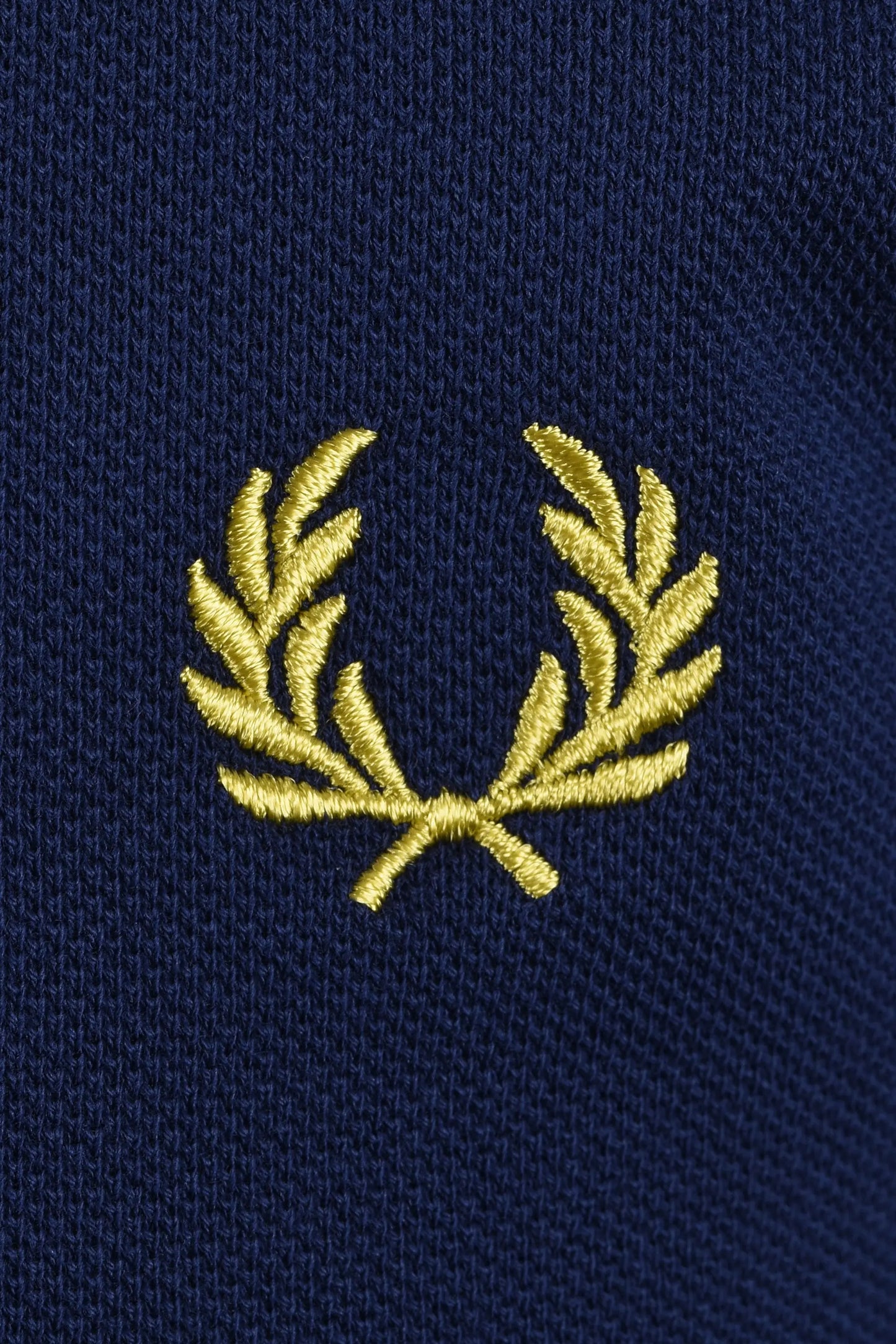 yellow embroidered fred perry logo on a navy blue polo