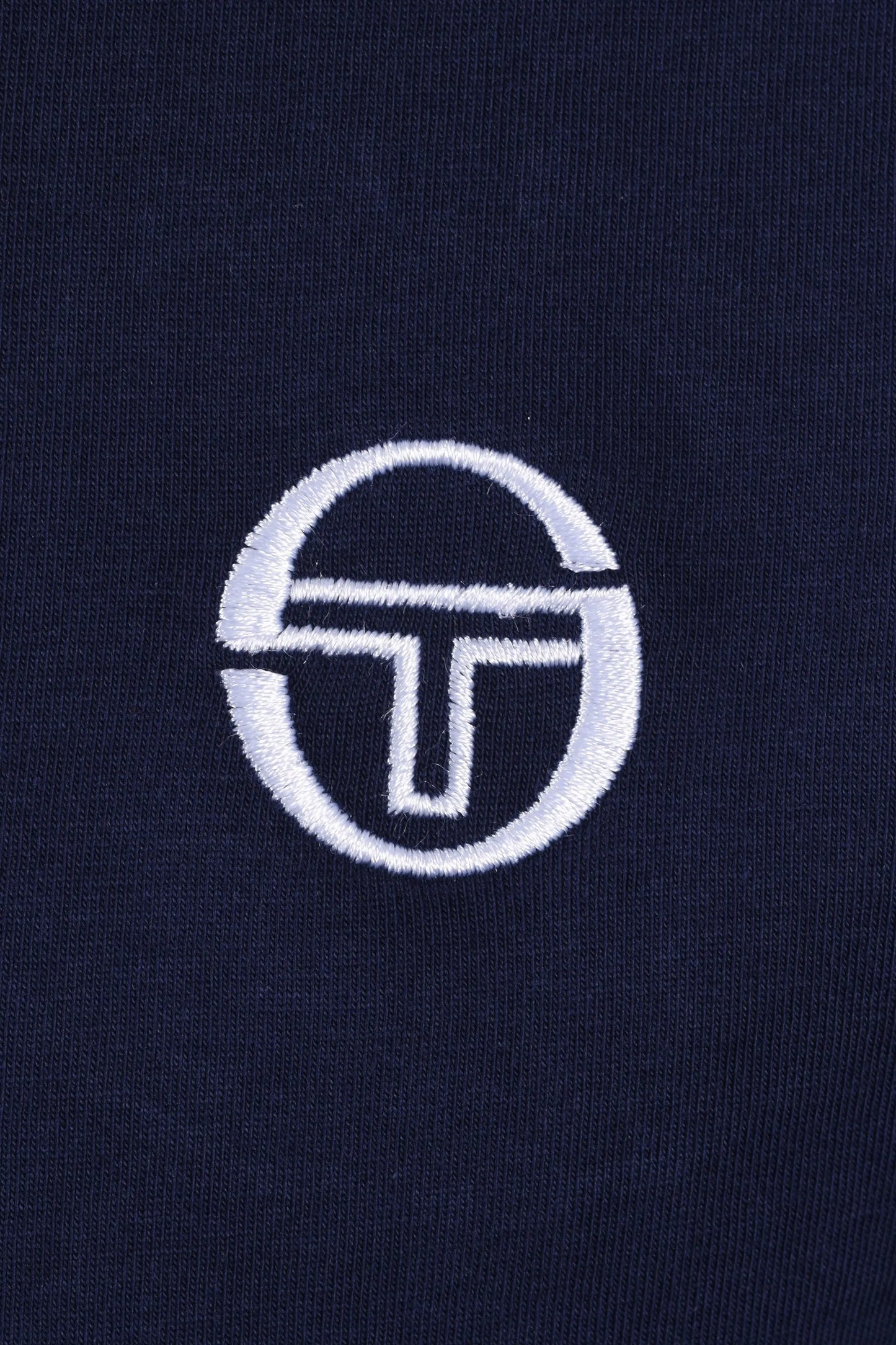 White sergio tacchini logo on a dark blue t-shirt