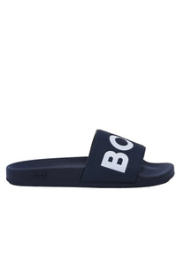 Side profile picture of a Boss Aryeh slider in the colour Dark blue with Boss written in bold upon the toe of the slider, pictured up on a white background.