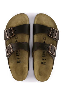Pair of brown BIRKENSTOCK  sandals with buckles on a white background