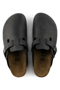 Pair of black leather BIRKENSTOCK sandals with brown soles on a white background