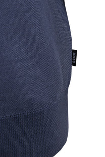 blue KNITTED TOP CLOSE UP OF a BOSS logo on a white background