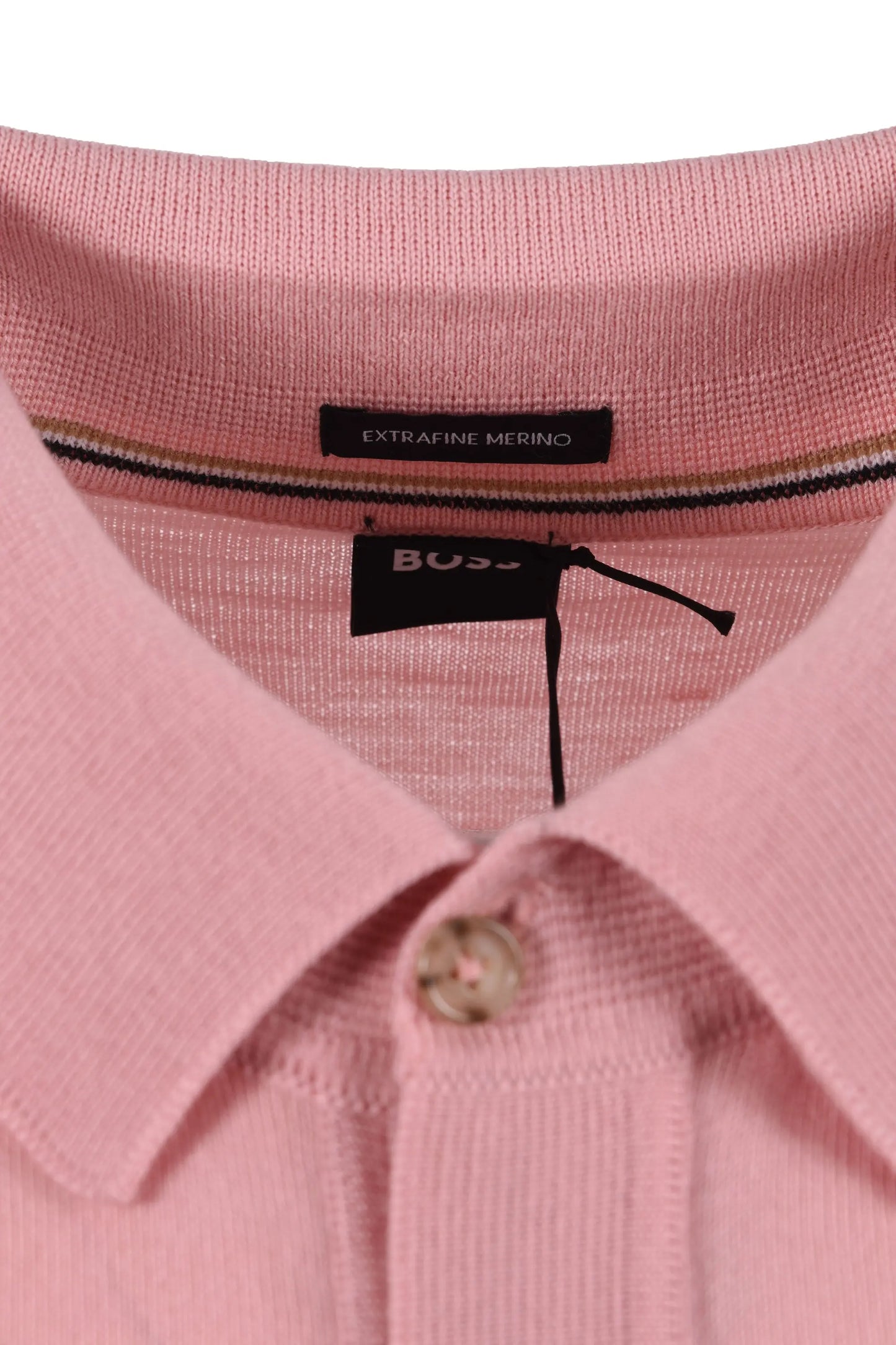Close-up of a pink polo shirt with a BOSS label on a white background
