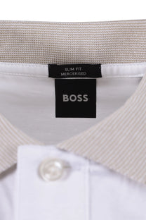 Close-up of a BOSS label on a white polo shirt with a beige collar.