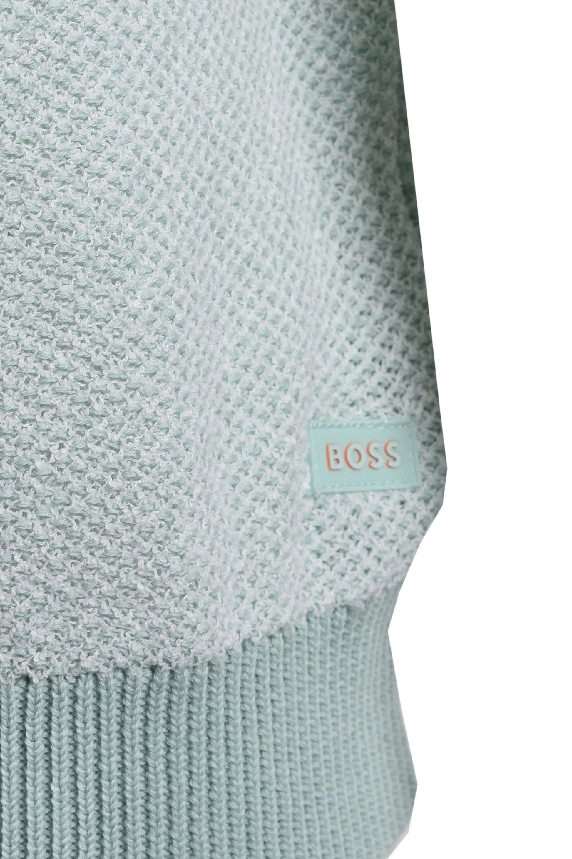 Close-up of a light blue knitted t-shirt with a BOSS label on a white background