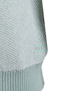 Close-up of a light blue knitted t-shirt with a BOSS label on a white background