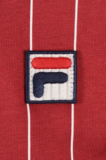 Close up of an embroidered Fila logo on a red background with white stripes