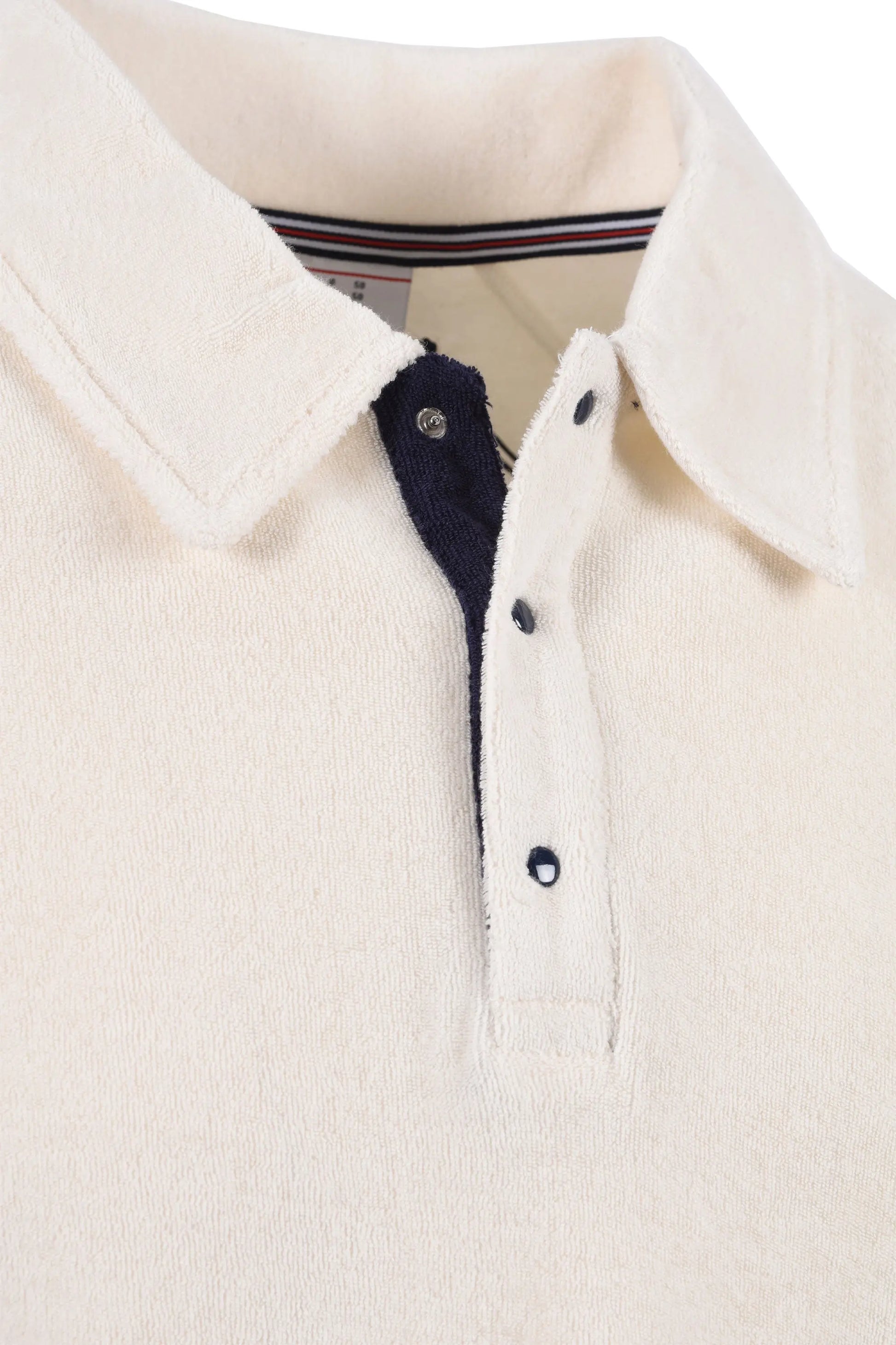 Close up of the collar and 3 press stud placket of a Fila Massimo terry polo in gardenia colour.