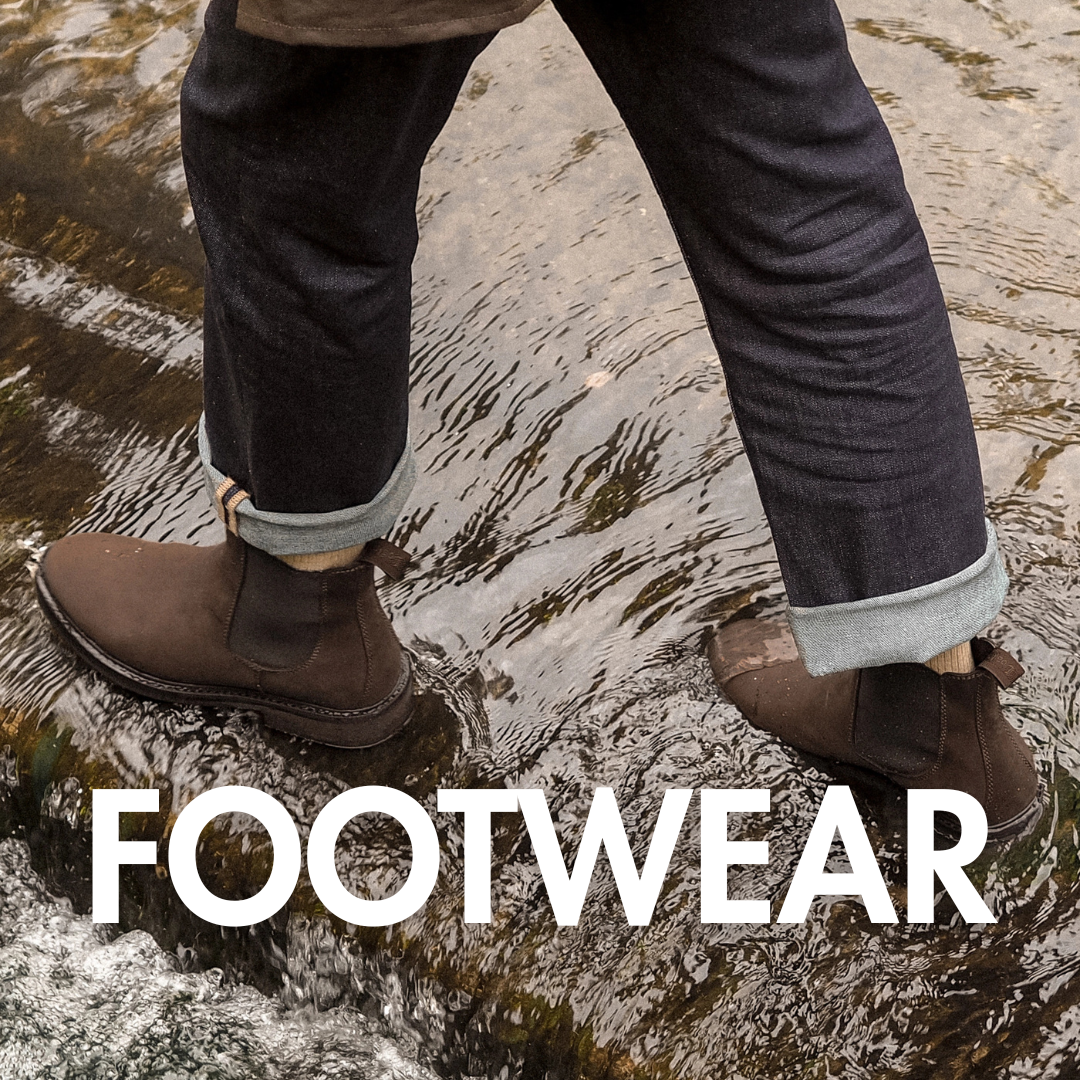 Footwear banner with a picture of a man wearing some jeans and some casual shoes or boots stood in a mud puddle in the background.