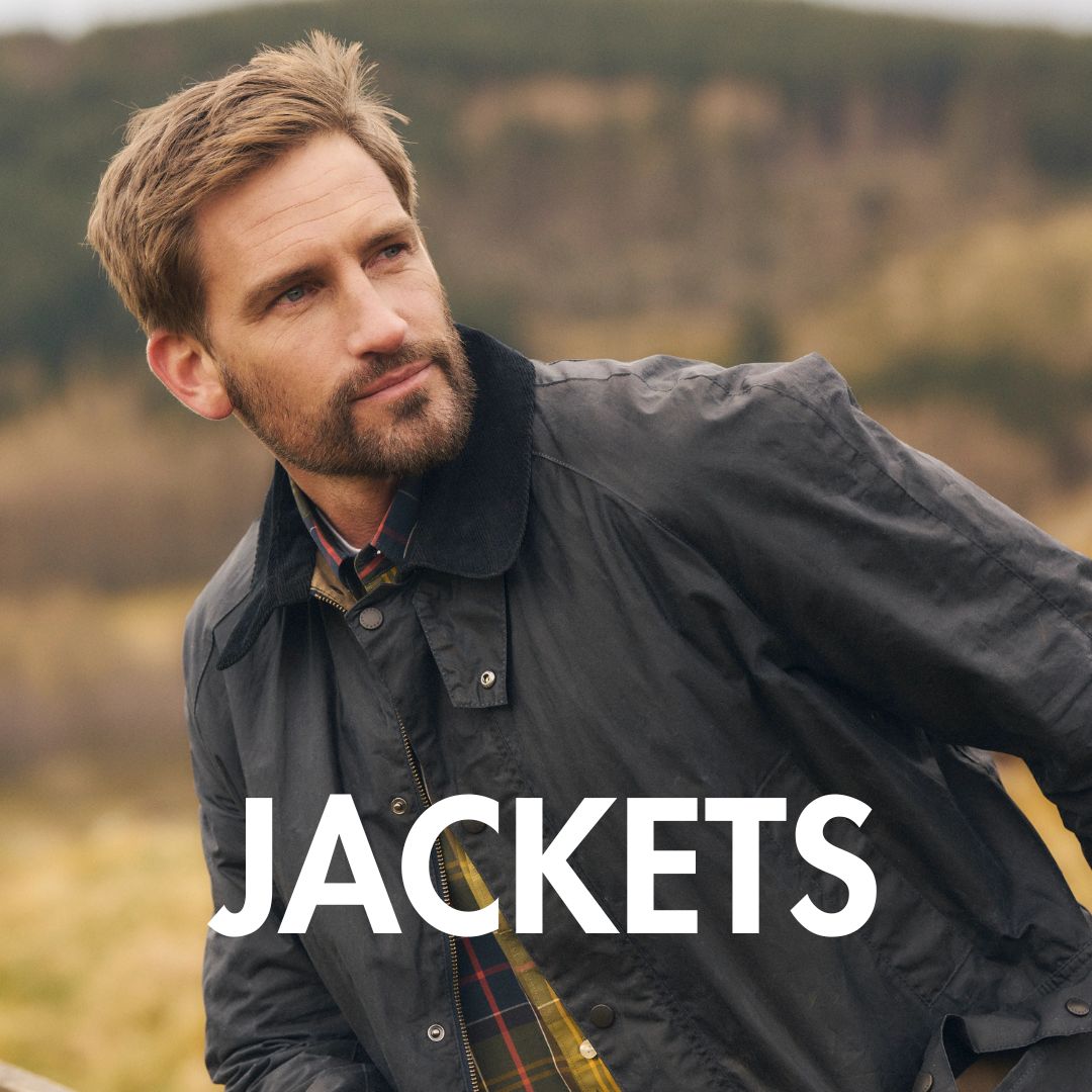 Jackets banner with a picture of a man wearing a Barbour jacket with a blurred mountain or countryside view in the background.