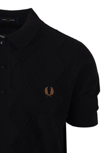 Black polo shirt with a Fred Perry logo in gold on a white background