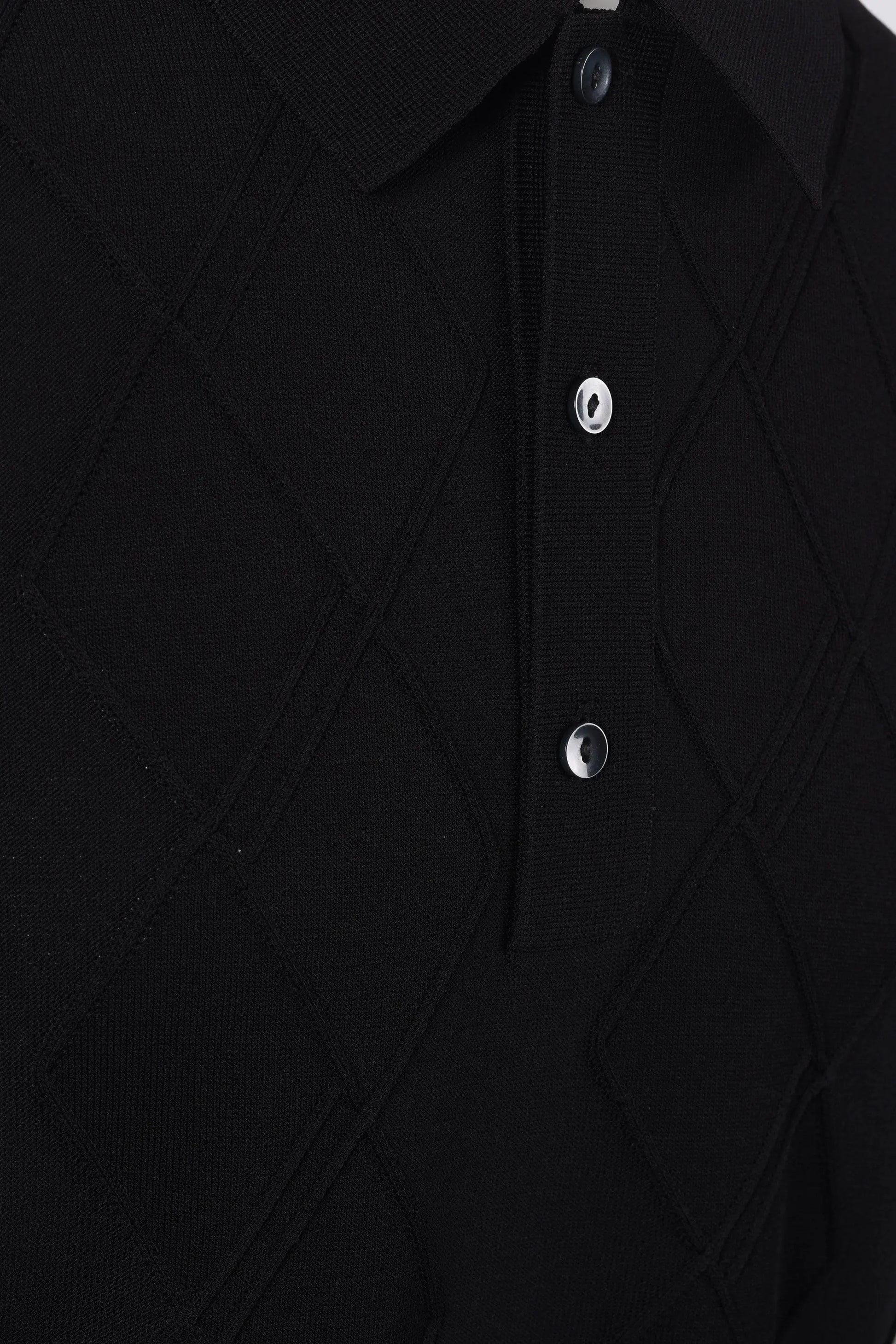 Close-up of a black textured Fred Perry shirt with buttons on a white background