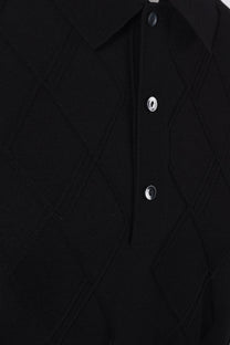 Close-up of a black textured Fred Perry shirt with buttons on a white background