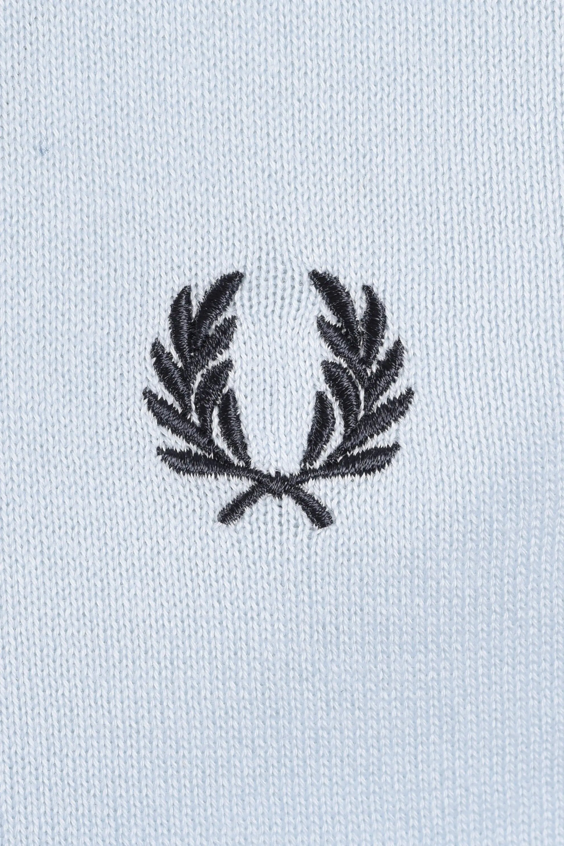 Embroidered fred perry logo on a light blue polo