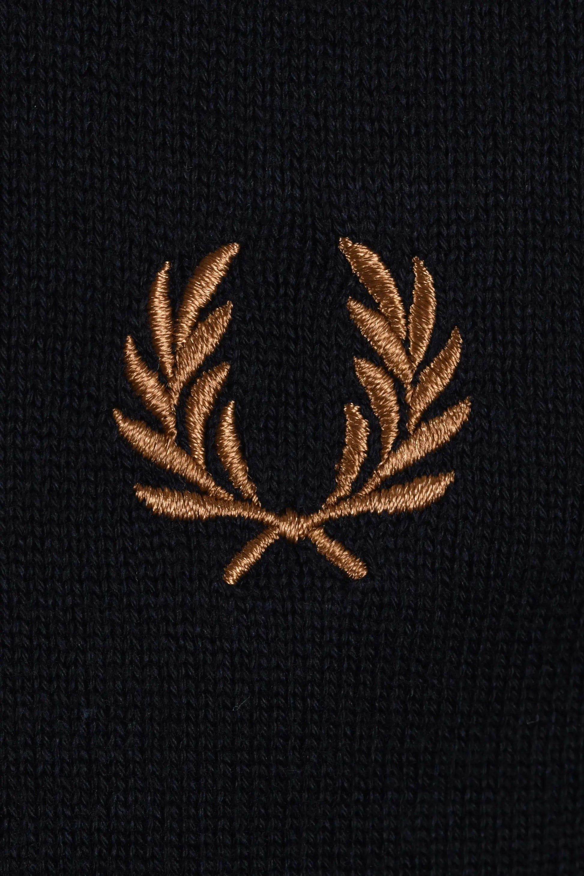 Embroidered gold  fred perry logo on a navy polo