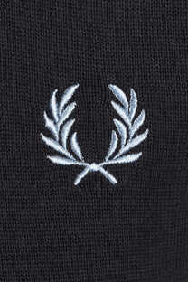 Close-up of a grey t-shirt with a white embroidered fred perry logo on a dark background