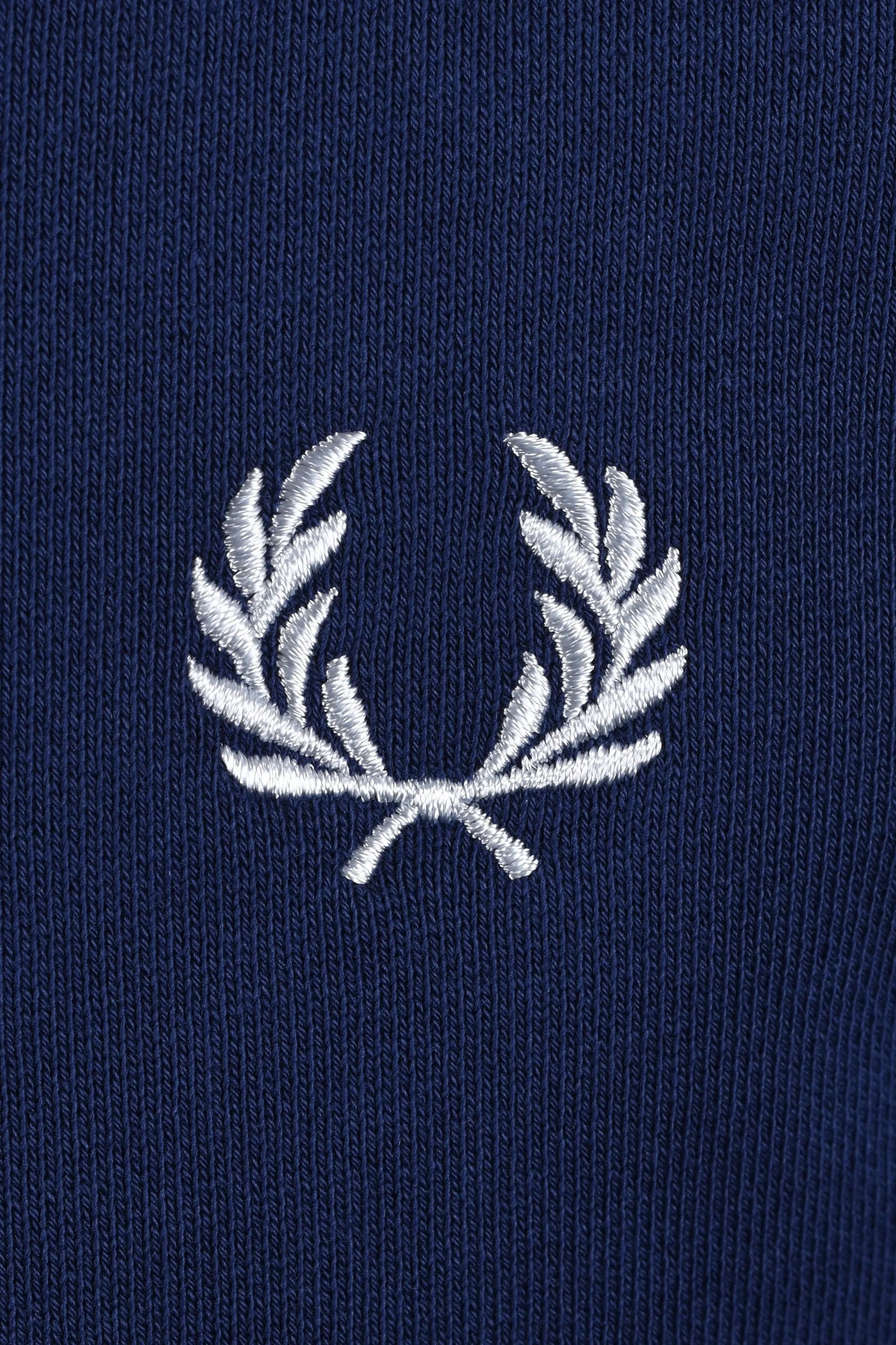 Embroidered fred perry logo on a navy swaetshirt close up

