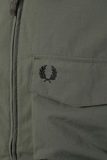 Close-up of a pocket on a jacket with a Fred Perry logo,