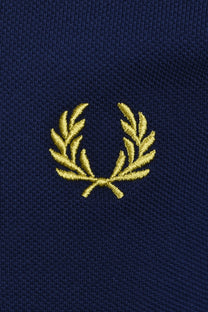 Navy blue polo with a gold fred perry embroidered logo