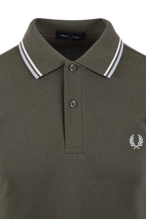 Green fred perry polo shirt with white collar and logo on a white background