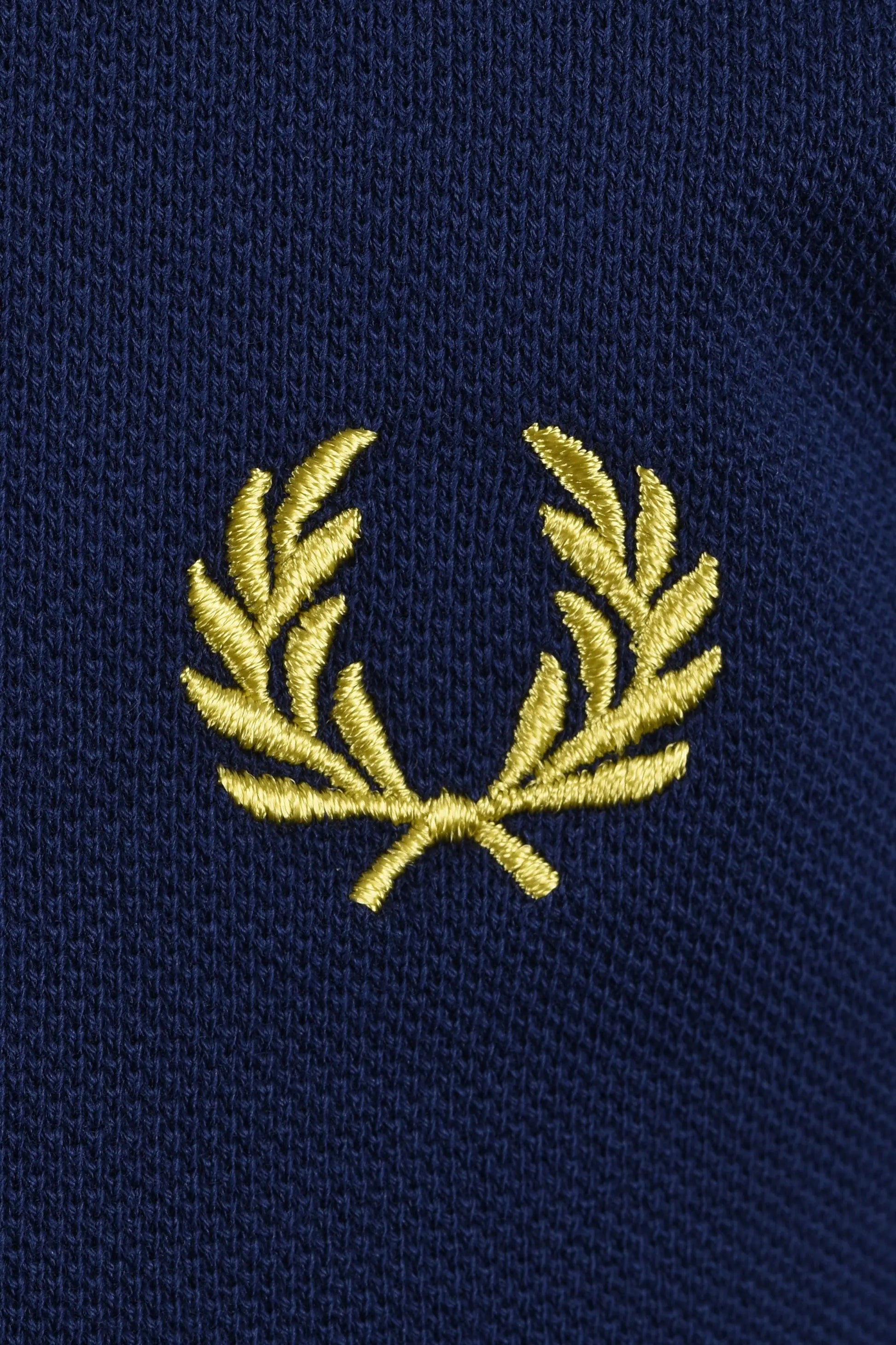 yellow embroidered fred perry logo on a navy blue polo