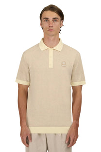A front facing picture of a man wearing a knitted Sandbanks polo in the colour beige with a matching beige coloured rubberised Sandbanks logo on the chest.