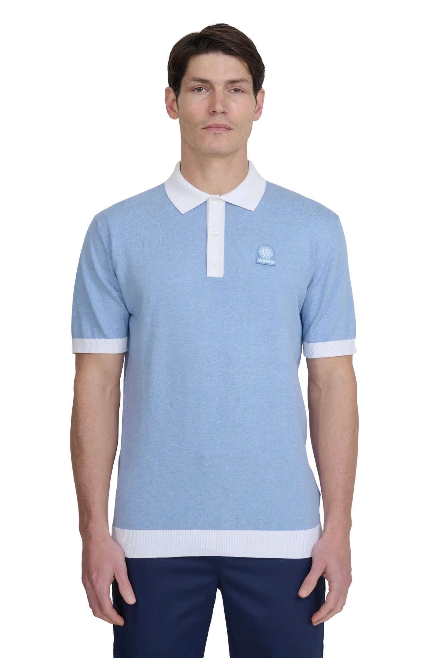 Man wearing a light blue sandbanks polo shirt with white accents on a white background