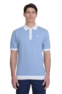Man wearing a light blue sandbanks polo shirt with white accents on a white background