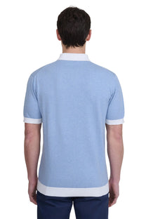 Man wearing a light blue sandbanks polo shirt with white accents on a white background
