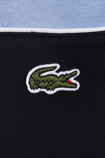 Close up of Lacoste crocodile logo upon a striped t-shirt background.