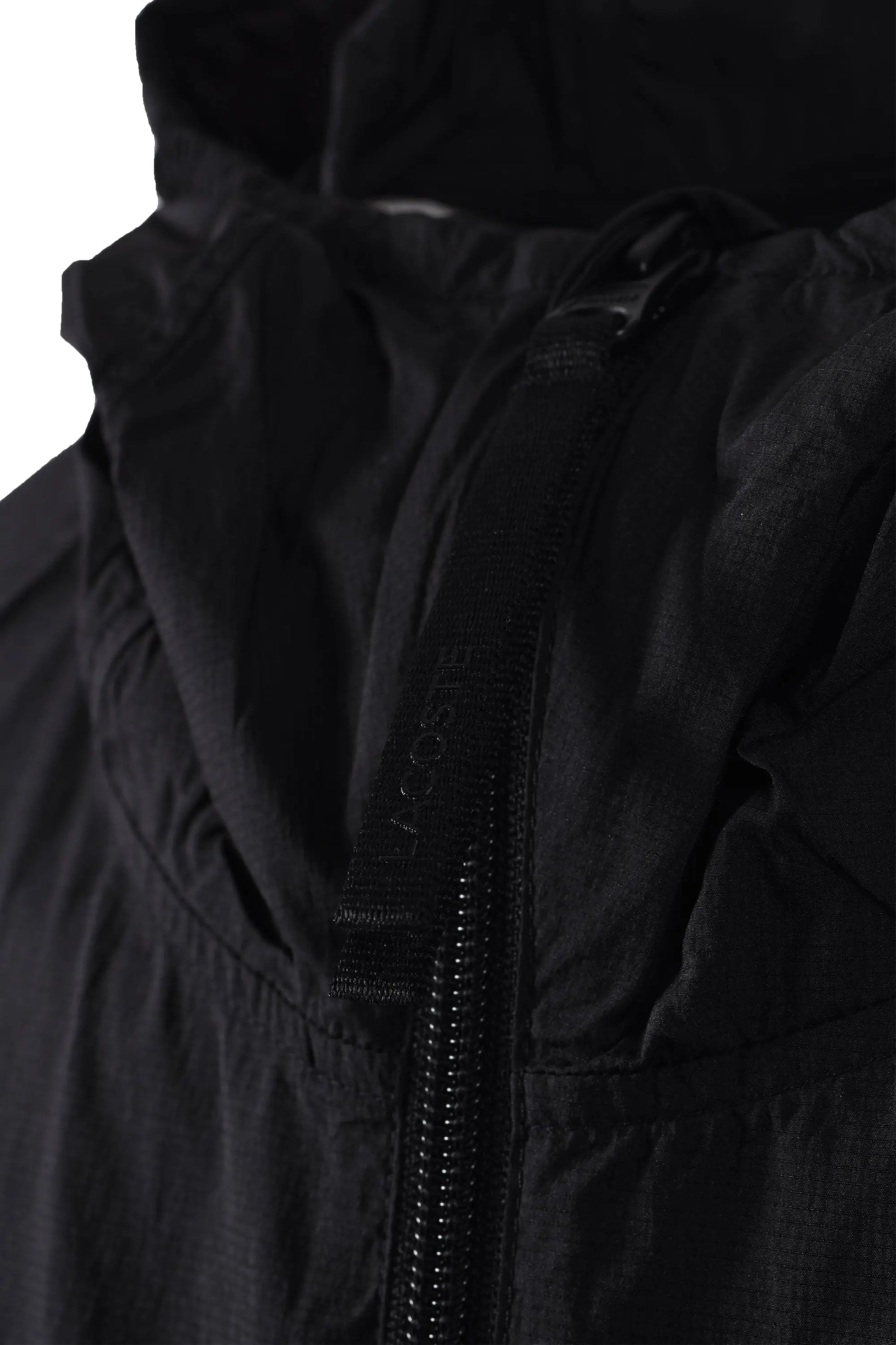 Close up of the branded Lacoste zipper on a lightweight jacket.