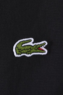 Close up of the embroidered Lacoste crocodile logo.