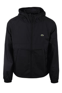 Full image of a Lacoste lightweight jacket in black, it has the embroidered Lacoste logo on the chest.
