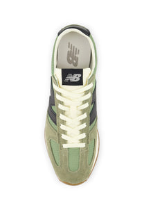Green sneaker with white laces on a white background