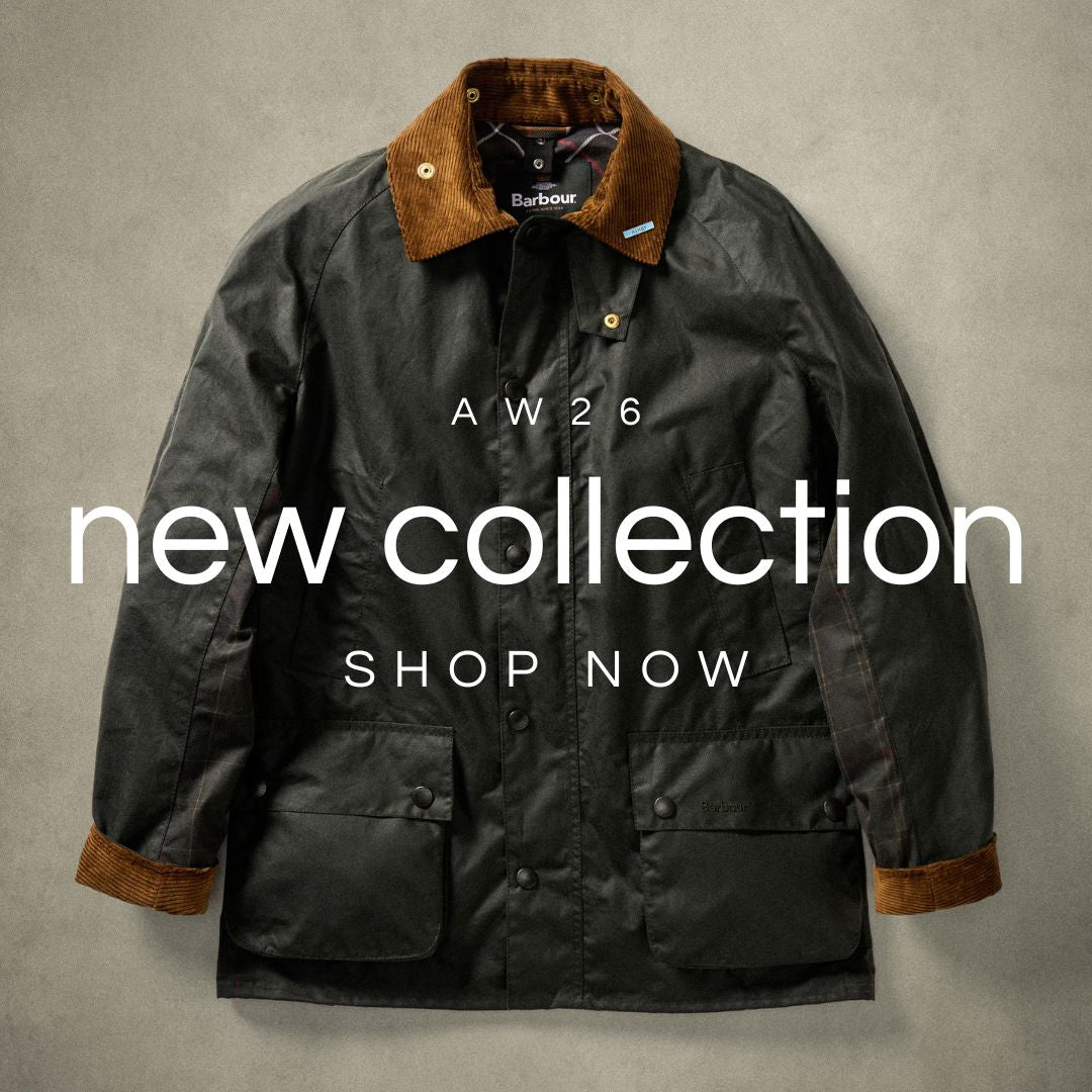 A Barbour waxed jacket in dark charcoal gray with brown corduroy collar and cuffs, laid flat against a textured gray background with 'AW26 new collection SHOP NOW' text overlay.