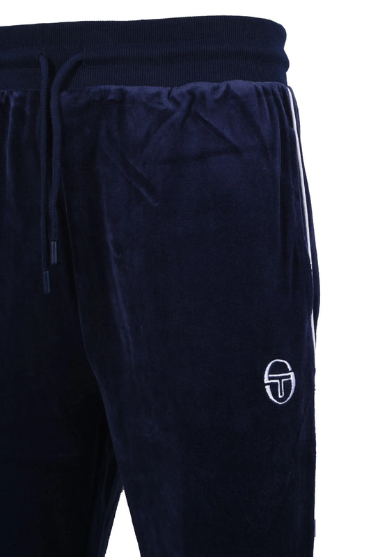 Side picture of a pair of Sergio Tacchini trackpants made from a velour material, featuring white stripe detailing down the side of the trackpant as well as an embroidered Sergio Tacchini logo in white on the front of the garment.