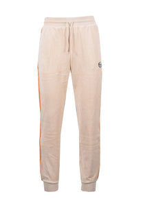 Full length picture of the Sergio Tacchini tack pants in a velour fabric. Salmon pink coloured material with a stricking bright orange piping along the leg.
