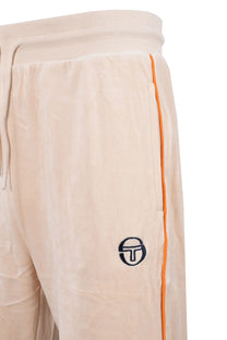 Side picture of a pair of Sergio Tachini track pants in a neutral colour in a velour fabric that features a orange piping down the side of the pant as well a the Sergio logo