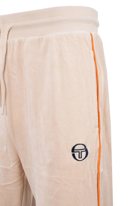 Side picture of a pair of Sergio Tachini track pants in a neutral colour in a velour fabric that features a orange piping down the side of the pant as well a the Sergio logo