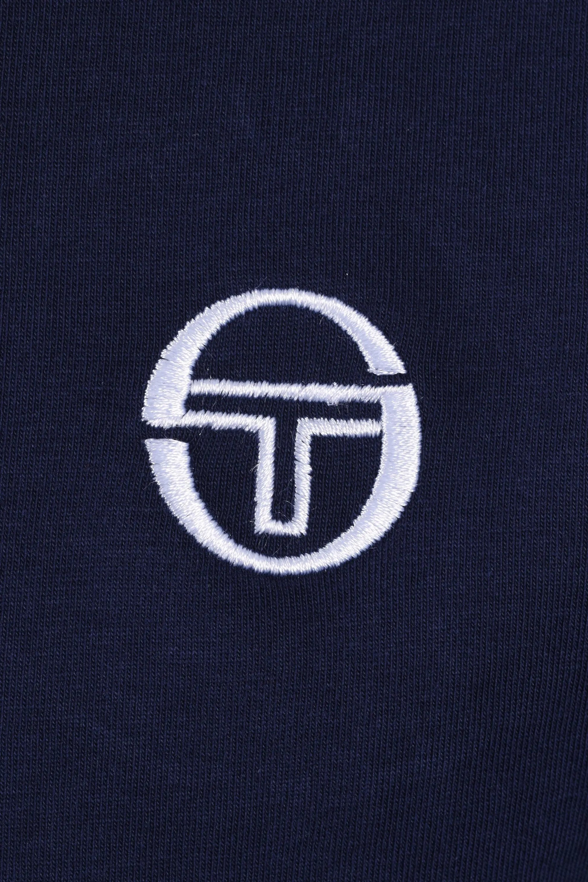 White sergio tacchini logo on a dark blue t-shirt 