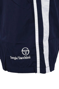 Bottom of the leg of a pair of Sergio Tacchini shorts in navy showing the Sergio Tacchini logo in white as well as a twin side stripe down the side of the leg of the shorts.