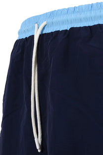 Close up of the drawstring waistband on a pair of Sergio Tacchini shirts in two different tones of blue.