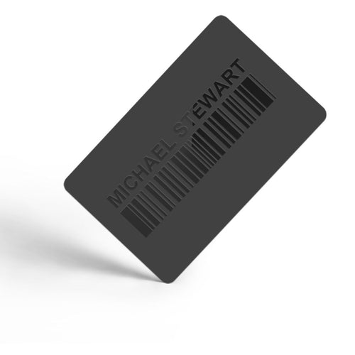 A dark grey rectangular gift card with rounded corners, featuring the embossed text 'MICHAEL STEWART' above a barcode design, shown floating at an angle on a white background.