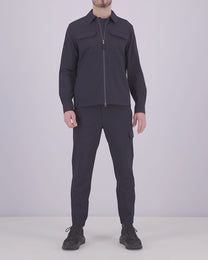 Man wearing menswear outfit in blue jacket and joggers or trackpants